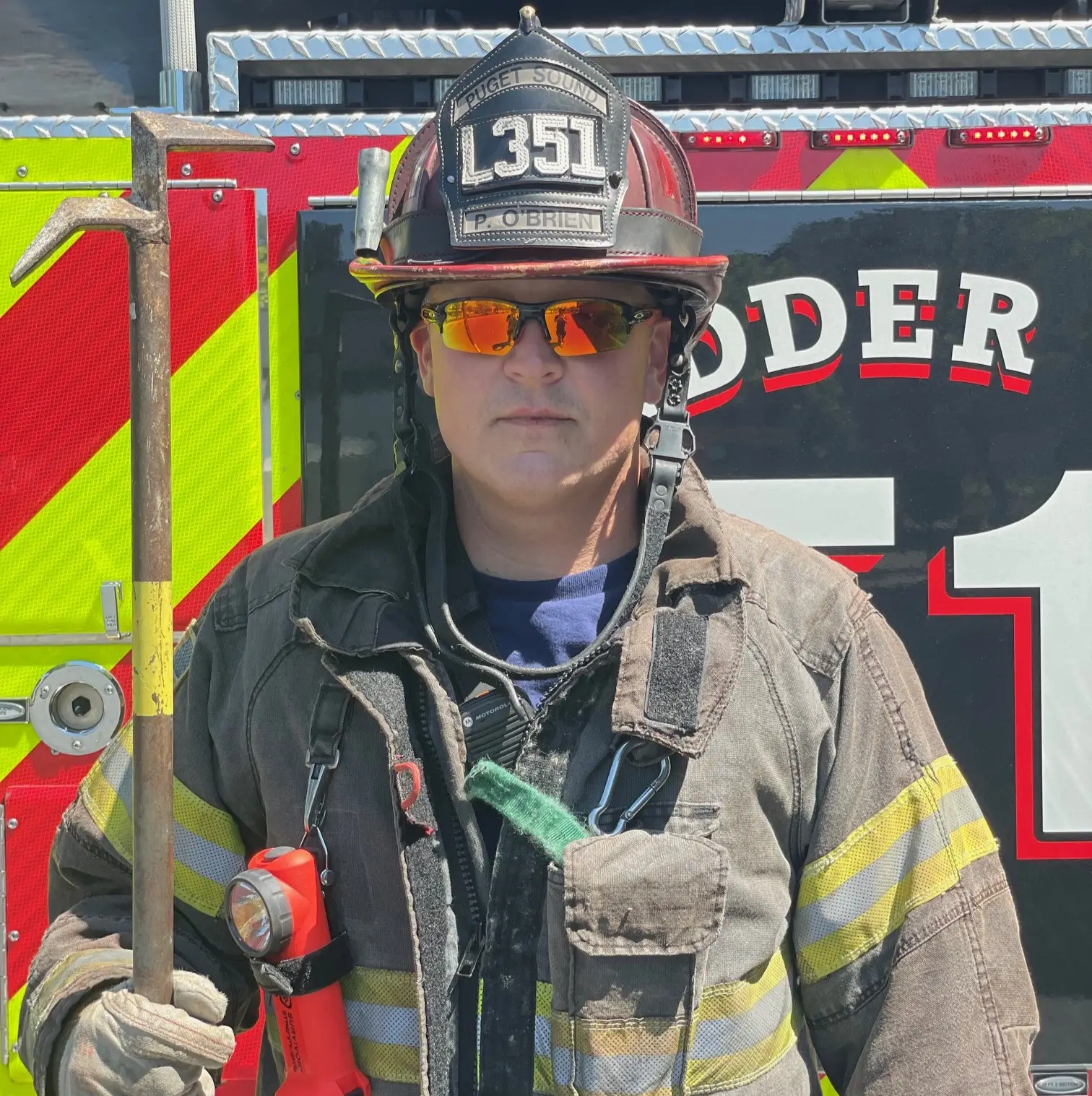 A fireman in front of a fire truck.