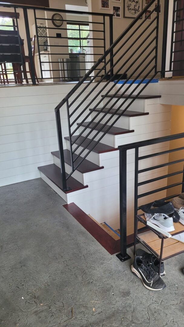 A staircase with metal railing and wooden steps.