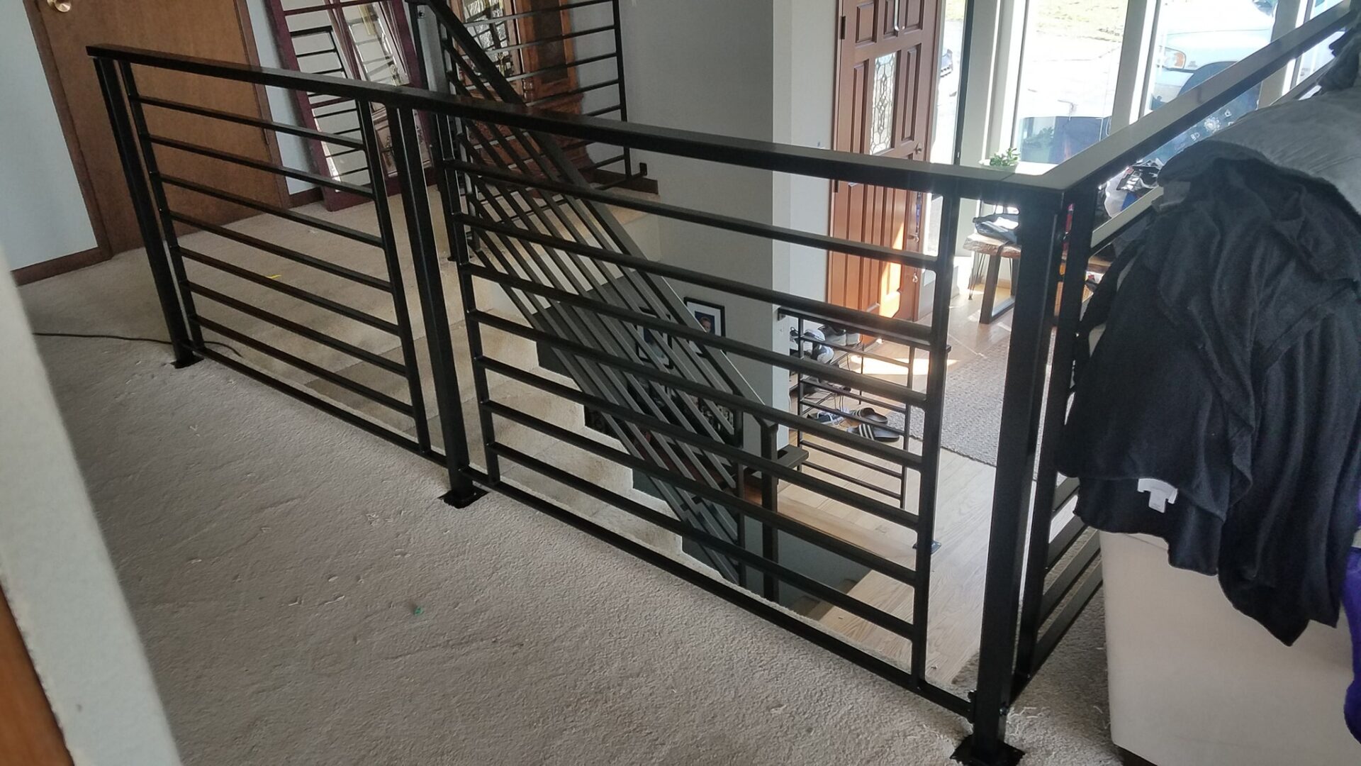 A metal railing with stairs going up the side of it.