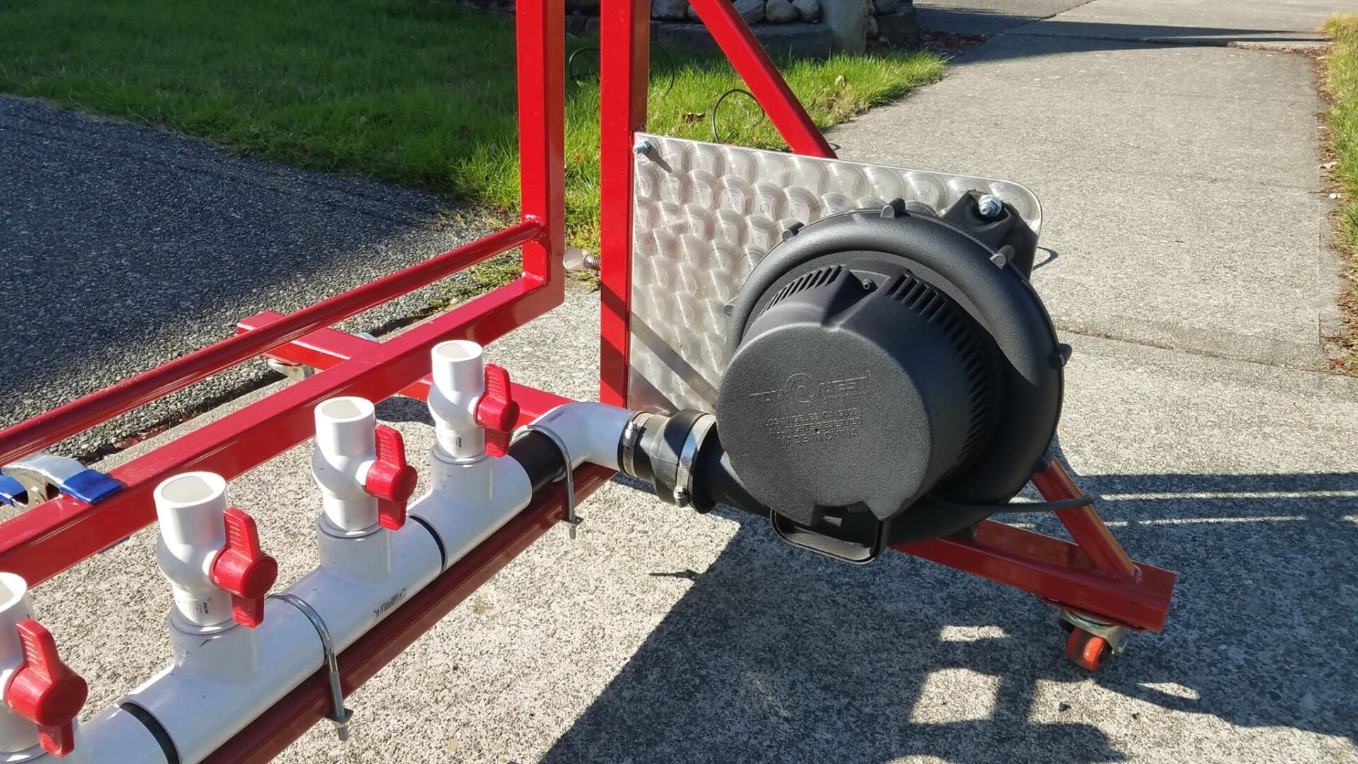 A black pipe sitting on top of a red rack.