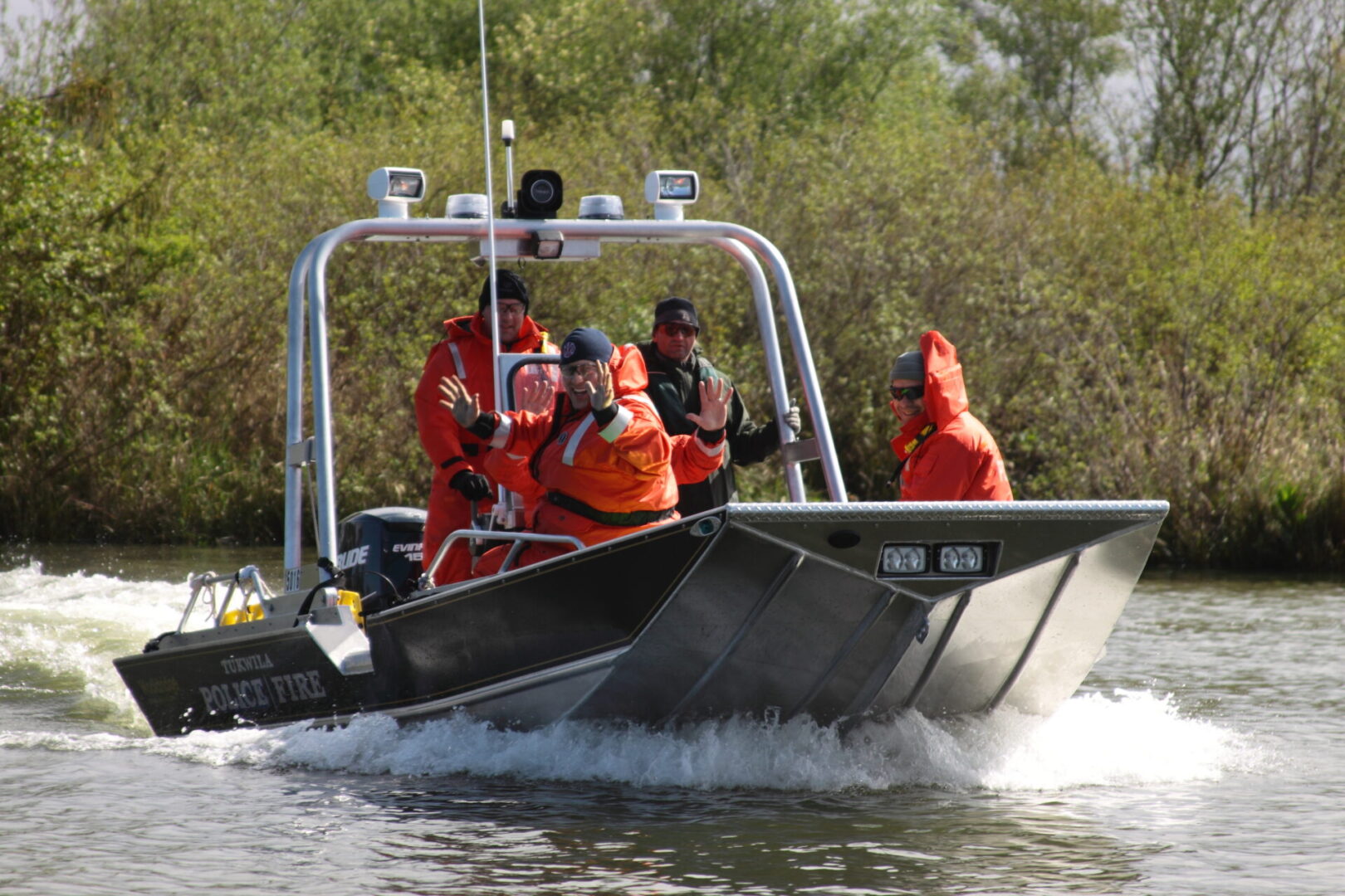 A group of people in orange suits on a boat.