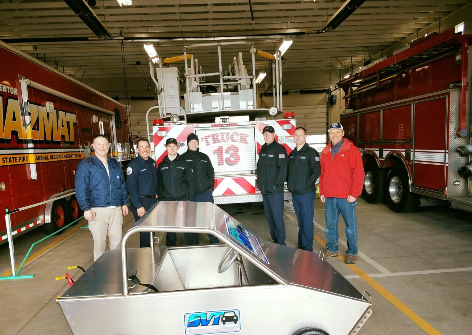 A group of men standing in front of a fire truck.