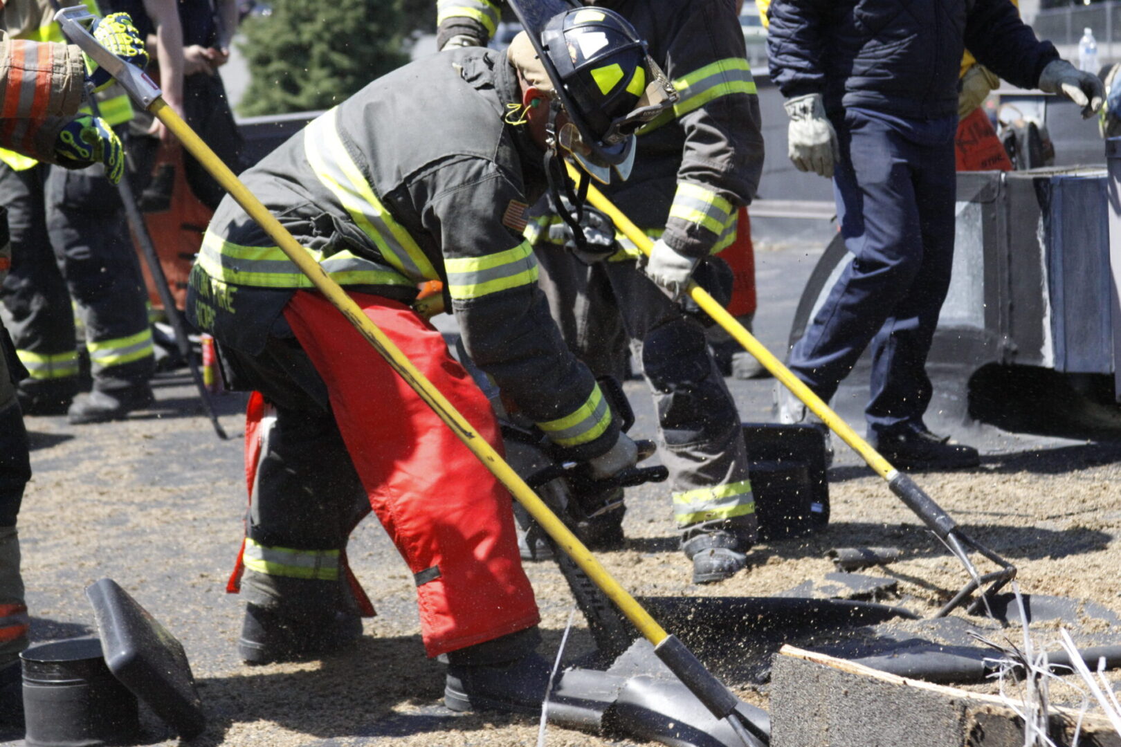 A group of firemen working on the side of a road.