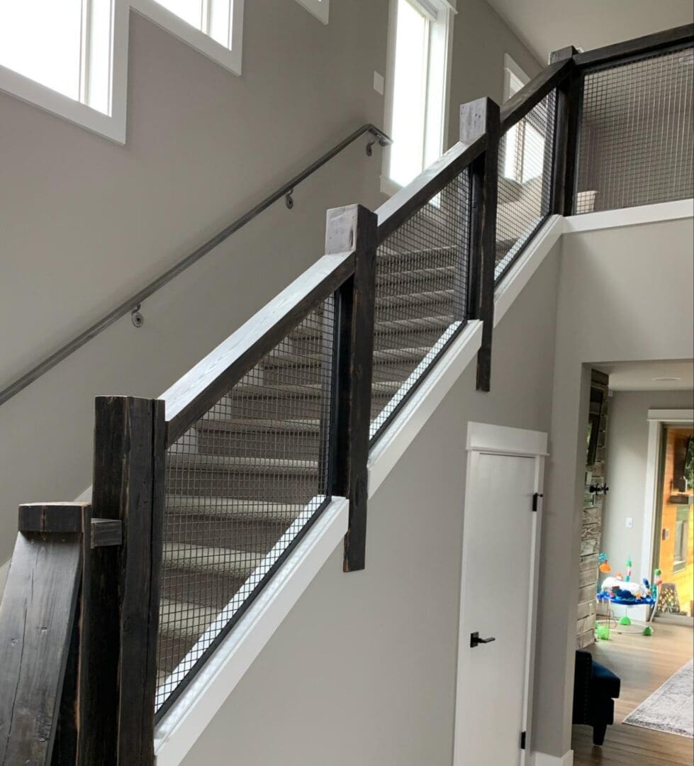 A staircase with metal railing and wood handrail.