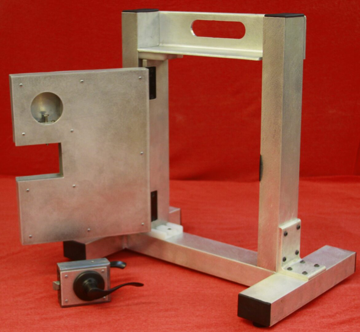 A metal frame with a door open and a camera attached to it.