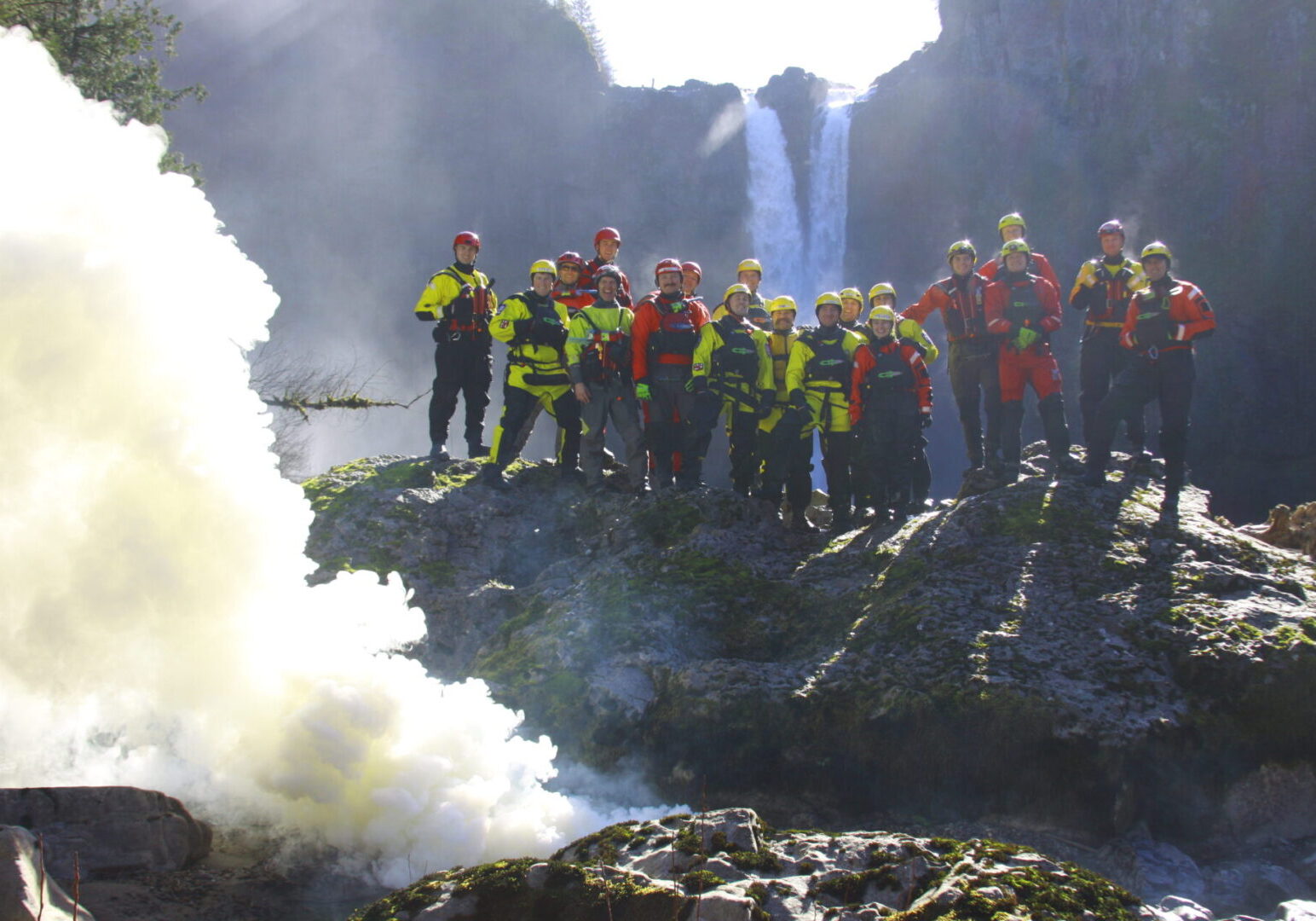 A group of people standing on top of rocks near water.